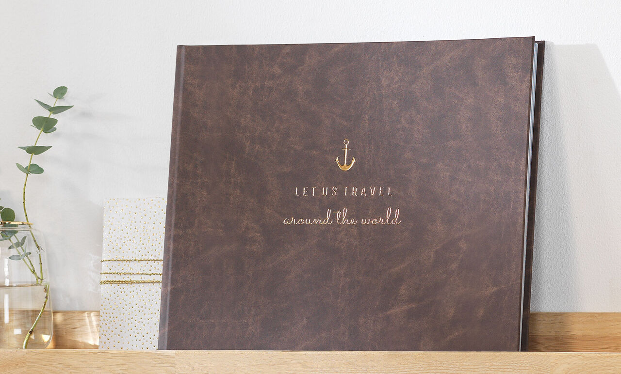 Brown photo book with gold lettering on the cover, placed on a shelf
