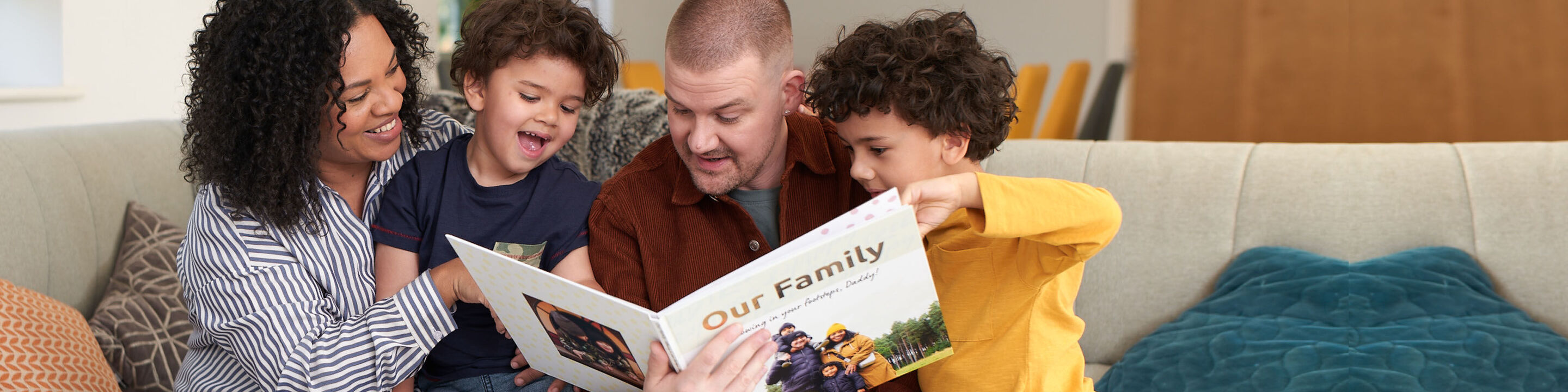 Family reading together in a photo book on the couch