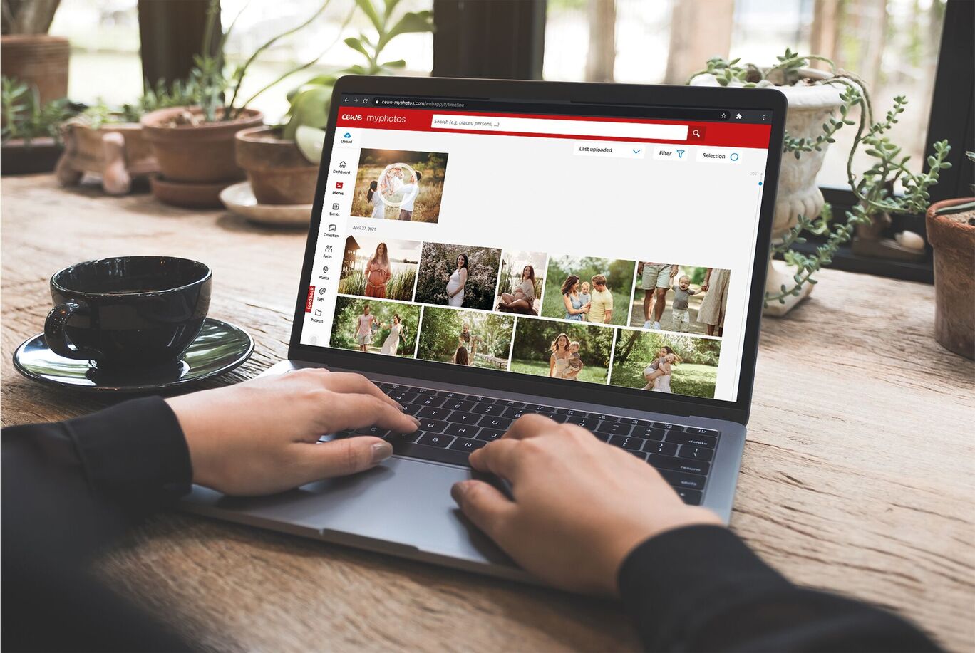 A person using a laptop to select photos for a later photo book.