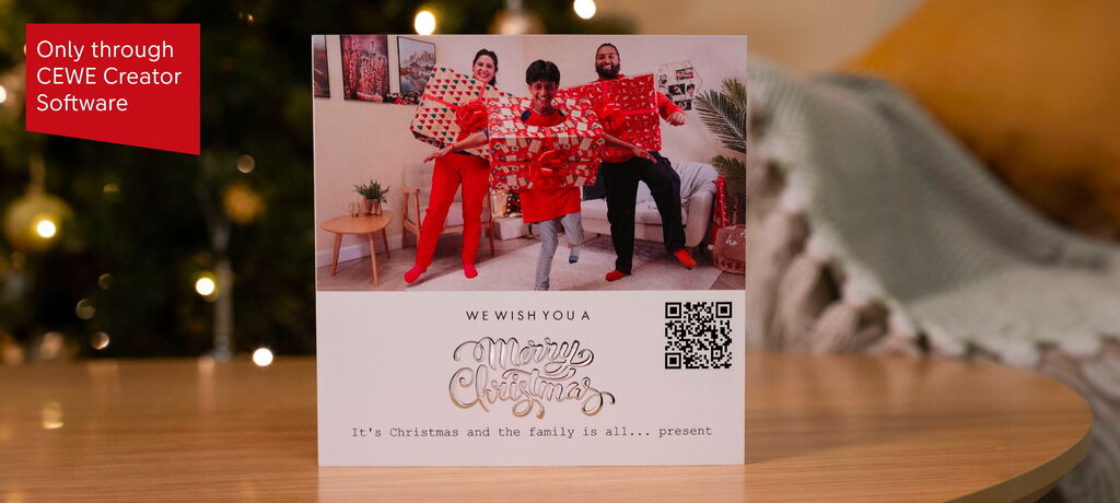 A family in red clothing holding gifts in front of a Christmas tree. The joy of celebration is visible.
