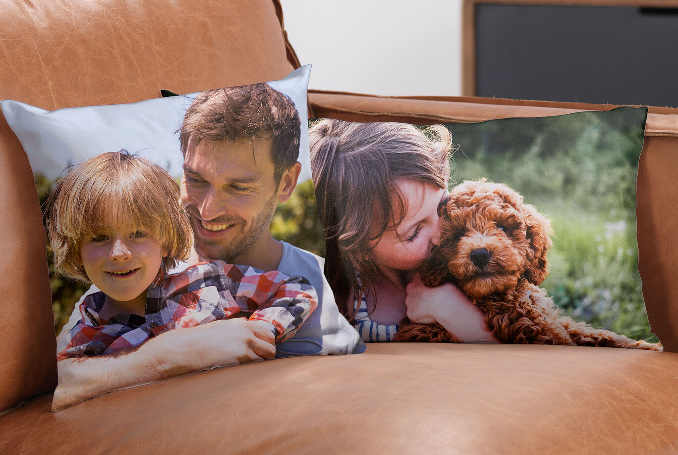 Two cushions on a couch show happy moments with children and a dog.